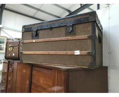 A brown travel trunk with beading