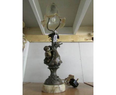 A table lamp with cherub base and glass shade.