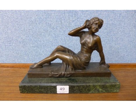 A French style bronze reclining lady, on green marble base
