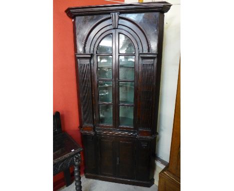 A George III style architectural walnut freestanding corner cabinet