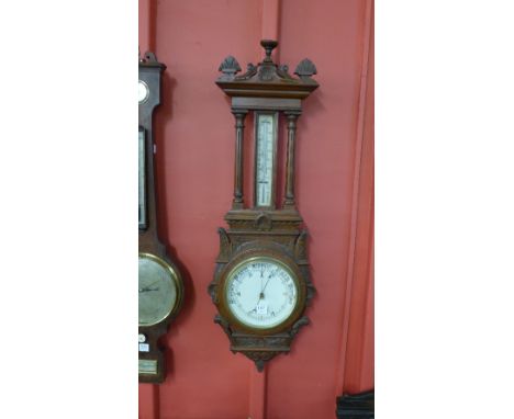 A Victorian carved oak aneroid barometer