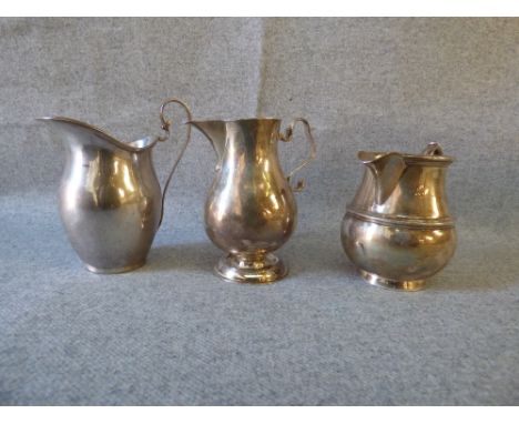 Edwardian silver cream jug, Chester 1902, of baluster sparrow beak form with a helmet shaped silver cream jug and another sil