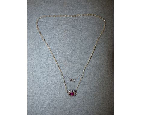 Victorian ruby and diamond clasp, the oval cut ruby 9mm x 6mm, enclosed by fourteen silver collet set old brilliant cuts tota