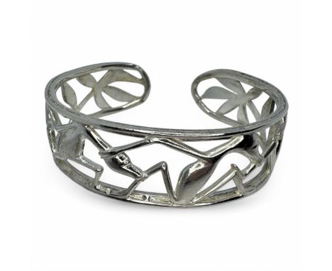 A Makonde openwork torc bangle, featuring Shetani Makonde folklore figures in movement. In white precious metal assessed as s