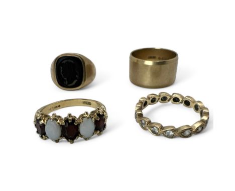 A group of four 9ct gold rings. Comprising a garnet and opal half hoop ring, size O1/2; a synthetic spinel full eternity band