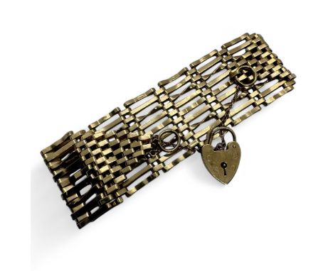 A 9ct gold gate bracelet with 9 bar panels. With heart padlock and safety chain. Approximate length 18cms. Gross approximate 