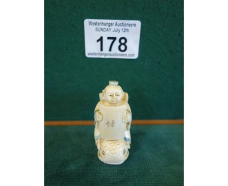 Carved Netsuke of a seated young Scholar sitting on a fish reading a book, 1.3/4" tall marked to the base and book, you can n