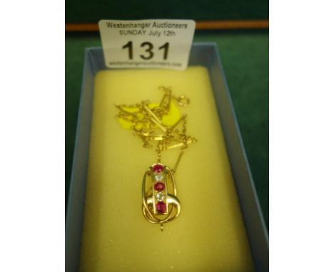 Gold coloured necklace with accompanying drop pendant, the pendant containing Ruby coloured stones, and clear stones, un-mark
