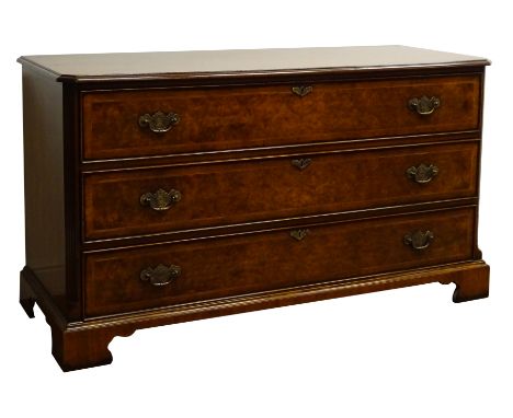 Reproduction bespoke walnut chest of three long drawers, with chased brass handles, reeded canted angles and on shaped bracke