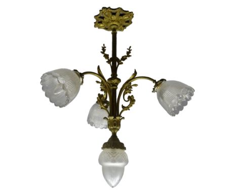 Early 20th century gilt metal four light electrolier, the pressed glass shades issuing on scrolling foliate cast arms above a