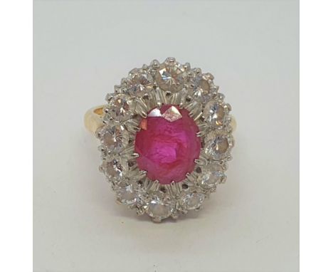 A Ruby and Diamond Cluster Ring claw-set oval mixed-cut ruby surrounded by a frame of twelve pavé-set brilliant-cut diamonds,
