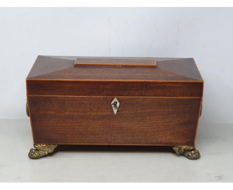 A Regency mahogany Tea Caddy of sarcophagus shape with satinwood stringing having two interior lidded compartments and glass 