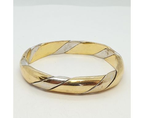 A bi-coloured twist Design Hinged Bangle, stamped 750, approx 37gms