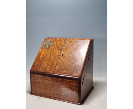 An oak Stationery Box by Carlisle and Watts, Edinburgh, the hinged folding and sloping front enclosing day, date and month ap