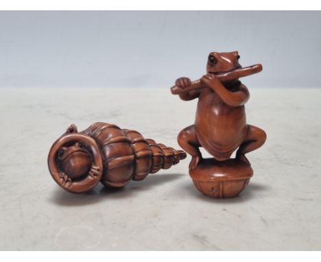 Two carved wood Netsuke in the form of a frog playing the flute and frogs wth a shell No obvious damage or repairs
