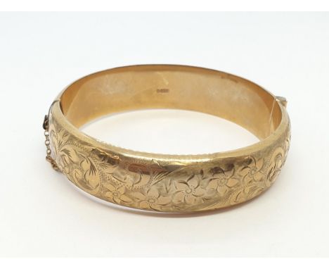 A 9ct gold hinged Bangle the front with scroll engraving, approx 22.50gms