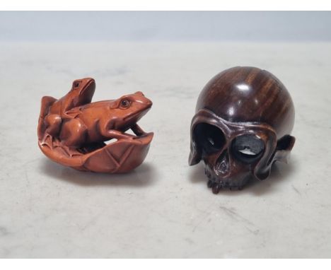 Two carved wood Netsuke in the form of two frogs on a leaf and a skull
