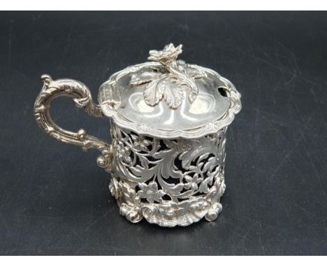 A William IV large silver pierced circular Mustard Pot with floral and scroll embossing, engraved crest, flower finial, Londo