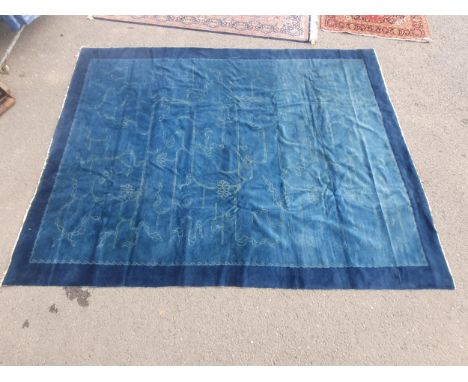 An early 20th Century Chinese Ningxia Carpet with dark indigo border and lighter field with a design of soft green vegetal la