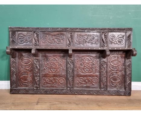 An antique carved oak Over mantle, with carved Dragon/Serpent design panels flanked by scrolled leafage carvings, with single