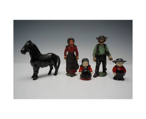 A unique collection of five vintage figurines featuring Amish-inspired characters and a horse, crafted from cast iron. The ca