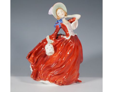 This Royal Doulton figurine, Autumn Breezes (HN 1934), beautifully captures a windswept maiden in a flowing crimson gown, acc