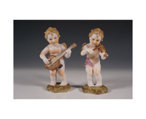 A charming pair of hand-painted Ardalt porcelain angel figurines, each depicted as a playful child musician. One angel is pla
