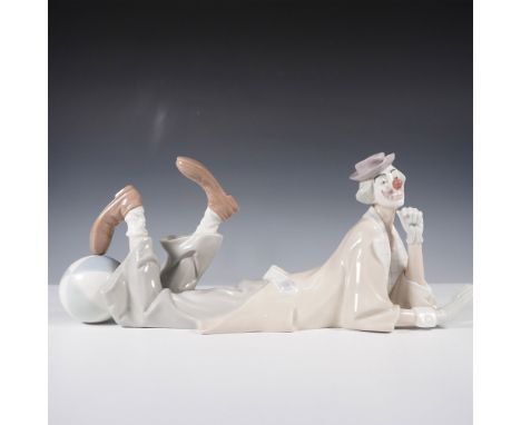 This Lladro porcelain figurine, Clown 1004618, features a cheerful clown reclining with a relaxed expression, dressed in soft