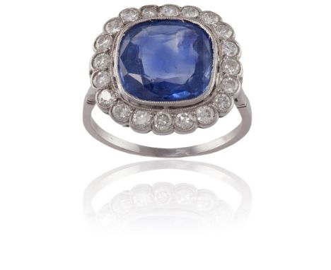 A SAPPHIRE AND DIAMOND CLUSTER RINGThe cushion-shaped sapphire, weighing approximately 4.70cts, within a scalloped surround o