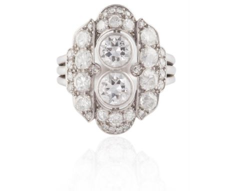 A DIAMOND RINGOf plaque design, set with two principal round brilliant-cut diamonds, within a surround of similarly-cut diamo