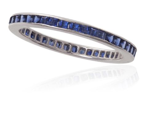 A SAPPHIRE FULL HOOP ETERNITY RINGChannel-set with a line of calibré-cut blue sapphires, mounted in platinum, ring size K
