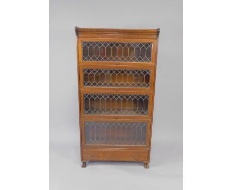 An early 20thC oak four tier Globe Wernicke style bookcase, with lead glazed doors, above a single frieze drawer, raised on l