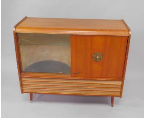 A Rema 1950's walnut cased radiogram, with a Monarch turntable, beneath a radio, flanked by a bowed display case with glass s