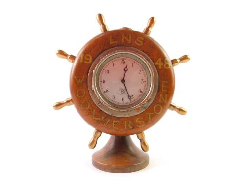 A 1948 LNS Woolverstone ship's wheel clock, the silvered Smiths car clock 8cm diameter dial, with Arabic numerals in a ships 