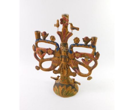 A naive plaster candlestick centrepiece formed as a 17thC style figure, flanked by raised flower heads, birds, stylised cheru
