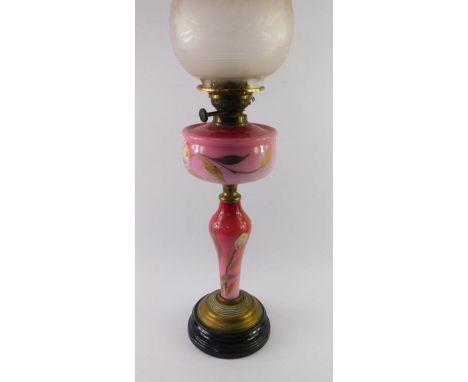 A Victorian brass and red opaline glass oil lamp, enamel decorated with flowers, with frosted and etched clear glass shade, 6