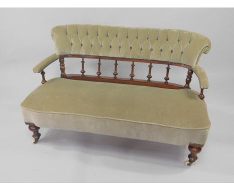 A Victorian mahogany open two seater sofa, upholstered in green button backed fabric, overstuffed seat, raised on turned legs