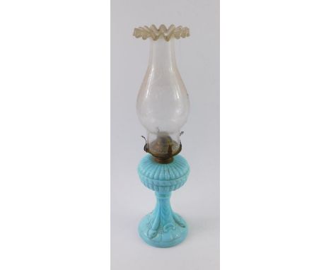 A Victorian turquoise milk glass oil lamp, moulded with sea serpents and shells, clear glass shade, 42.5cm high.