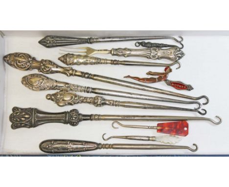 A collection of mainly hallmarked silver handled and other button hooks, together with an enamel "Mother" brooch marked 'Silv
