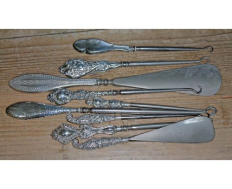 A group of nine hallmarked silver handled button hooks and shoe horns.  