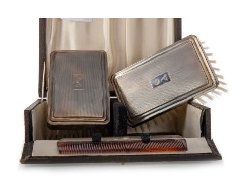 the two engine turned brush tops with engraved initials, along with a comb, in fitted case   