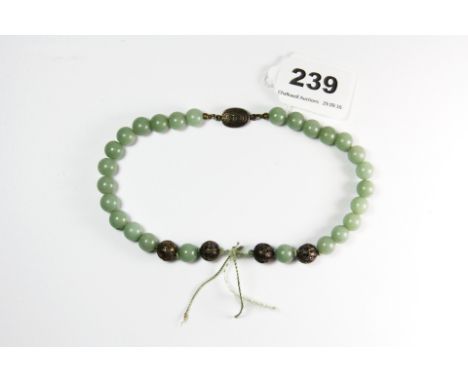A short strand of early 20th century Chinese 9.5mm nephrite jade beads with filigree silver beads and original Chinese silver