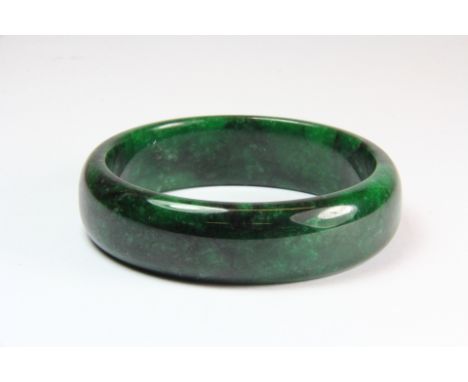 A fine dark green jadeite jade bangle, approx. 81g, W. 1.8cm, internal Dia. 6.2cm. Est. £150 - 200