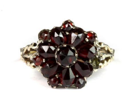 An antique yellow metal (tested 9ct yellow gold) garnet cluster ring (K), (one small garnet missing).