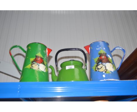 An enamel kettle with swing handle and two decorated enamel water jugs