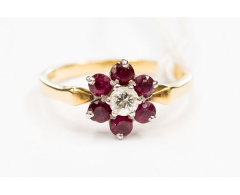 A ruby and diamond flower cluster ring, claw set central brilliant cut diamond of approx 0.2 ct and six surrounding rubies, s