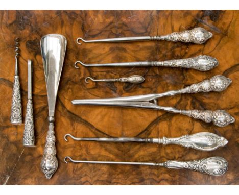 A bag of embossed silver handled and white metal handled button hooks, glove stretchers, etc 