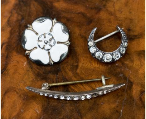 A silver and enamelled brooch, York rose, white enamel, together with Continental silver and paste crescent brooches (3)