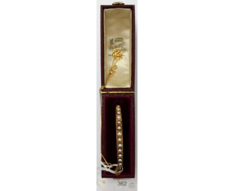 A 9ct gold chain approx 18''; together with a yellow metal and pearl bangle in original case. The bangle is set with thirteen