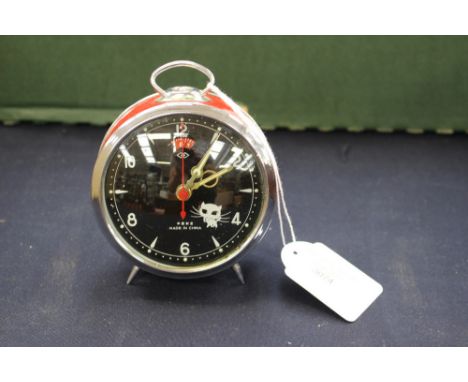 A Chinese red and steel cased alarm clock with a cat eye mechanism design